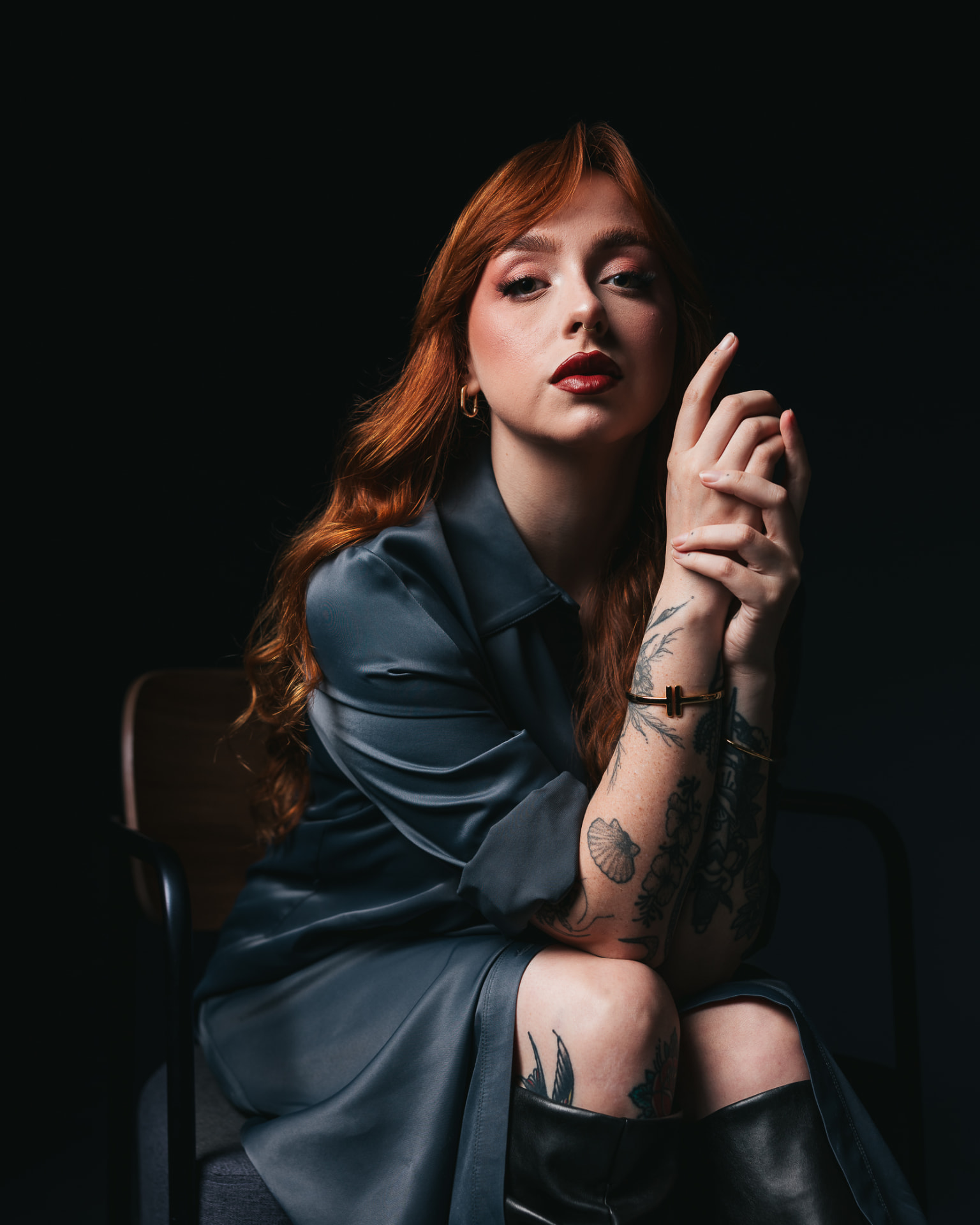 Retrato de mulher ruiva sentada com luz recortada