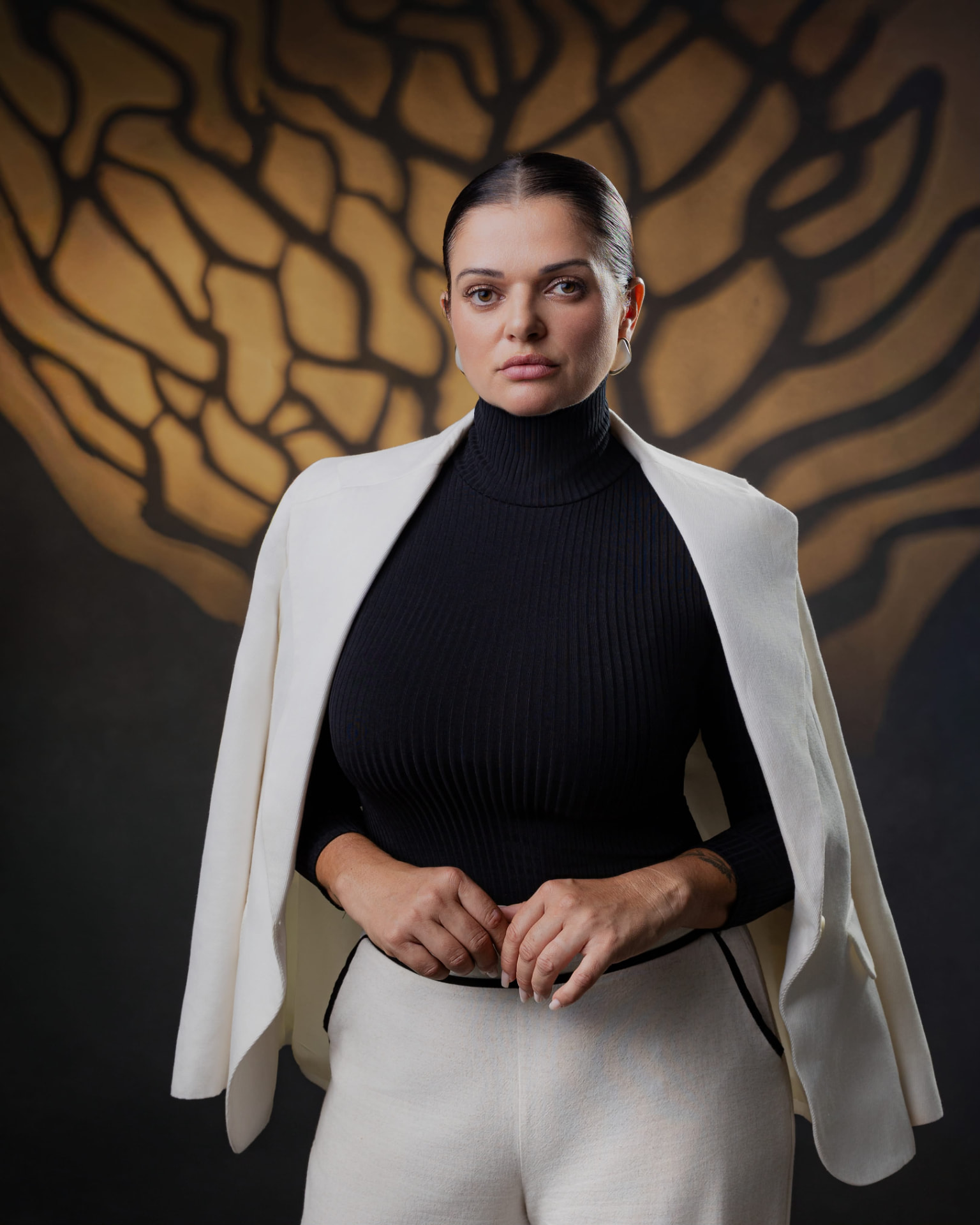 Retrato de mulher com blazer branco e fundo autoral